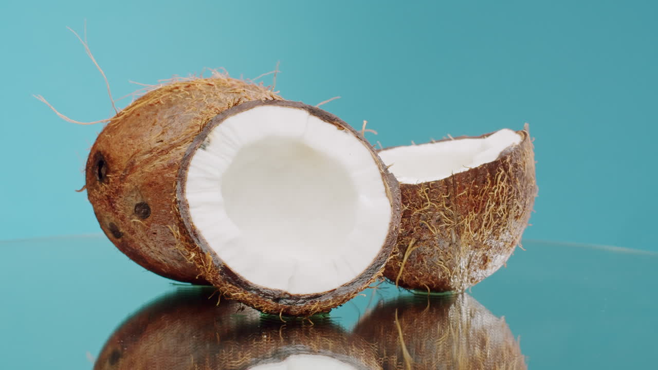 Close-up of a whole and halved coconut