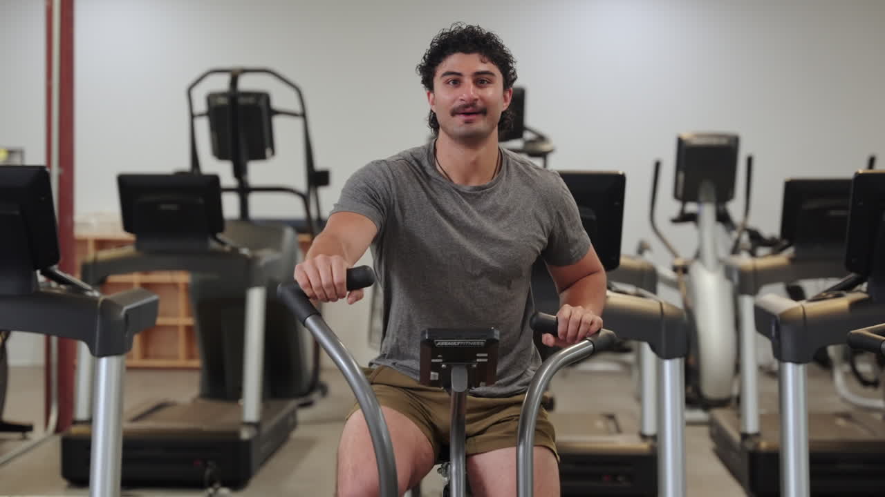 Man doing endurance exercise on an assault bike, front view