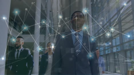 animation of network of connections over diverse male and female colleagues walking in office