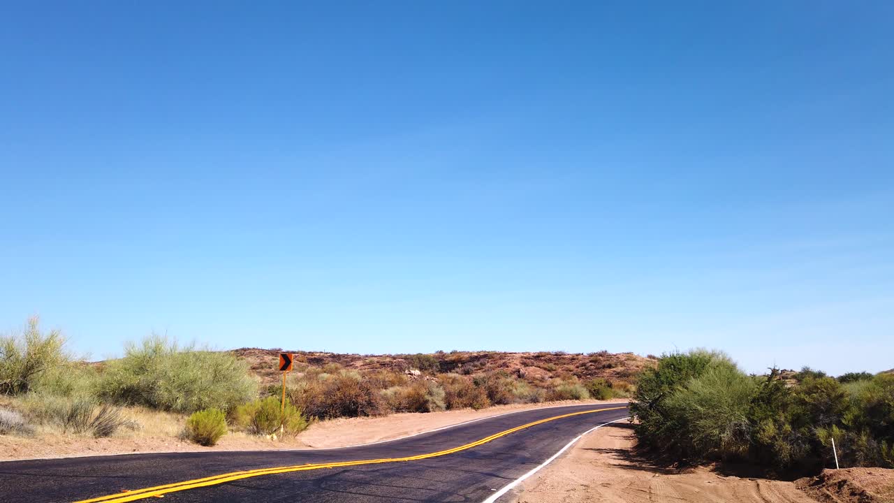 AN SUV dragging a packed trailer zooms along a desert highway to parts unknown, Scottsdale, Arizona.