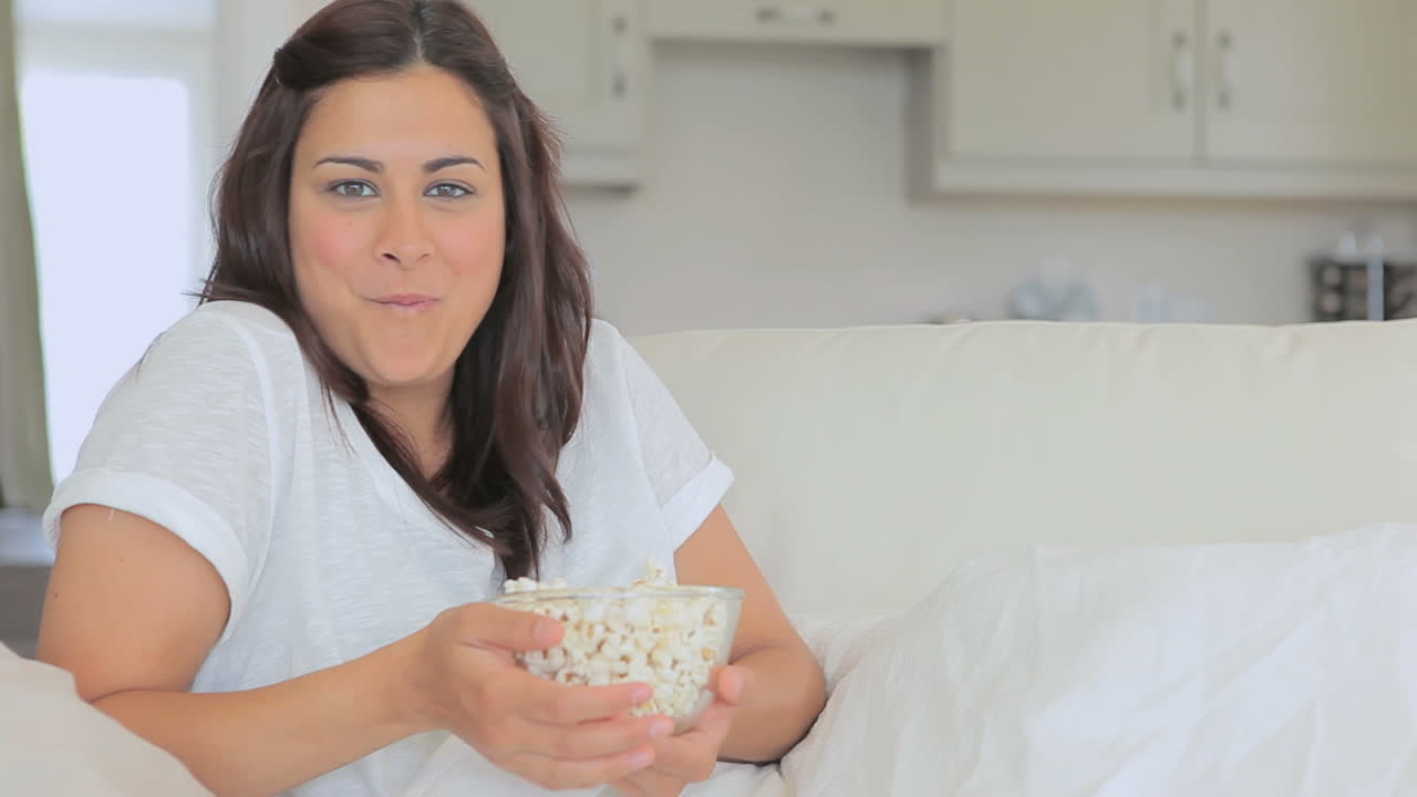 Vídeo de mulher comendo pipoca enquanto ri