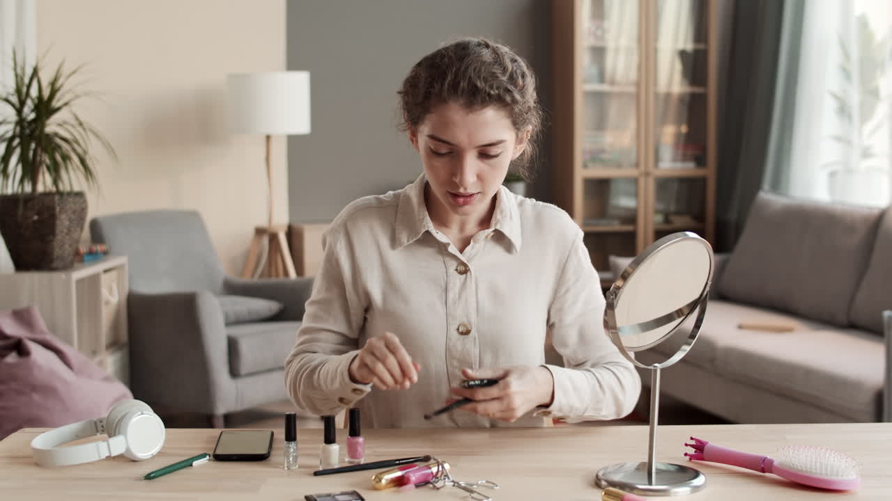 mujer haciendo maquillaje y usando el teléfono