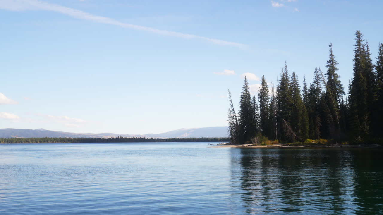 Lac Jenny String, Parc National de Grand Teton : eau glaciaire époustouflante d'une clarté cristalline, automne, météo parfaite, ciel bleu, milieu d'après-midi, mouvement panoramique cinématographique lent vers la gauche