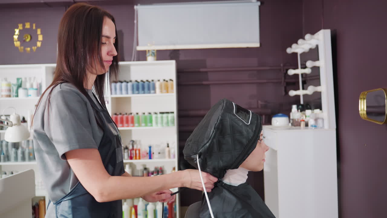 stylist forbereder hårbehandling, stylist klargør værktøjer til dybdegående balsam, professionel stylist arrangerer og justerer salonværktøjer for at lette en intensiv hårbehandlingsproces
