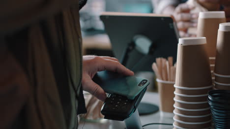 young-african-american-barista-man-serving-customers-in-cafe-using-credit-card-making-contactless-payment-buying-coffee-spending-money-enjoying-service