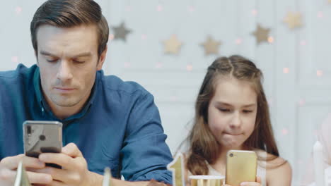 Portrait-of-concentrated-father,-daughter-and-mother-watching-mobile-phone-in-living-room