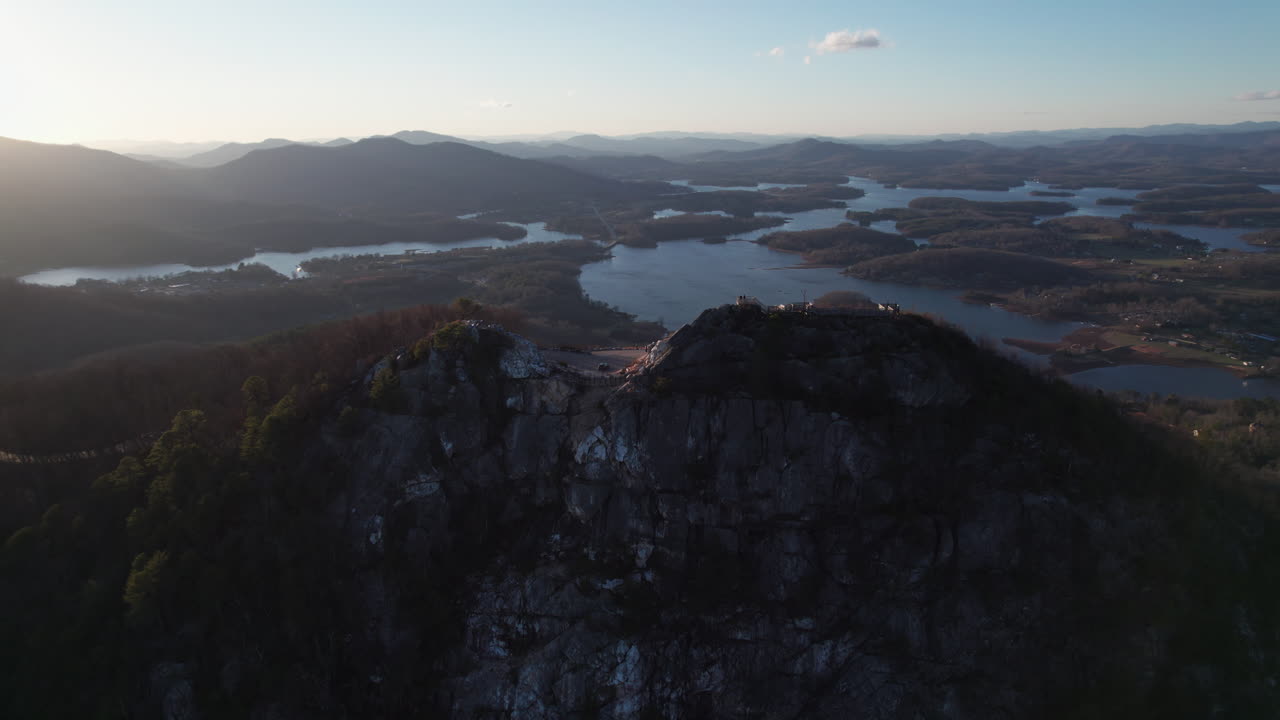 Epic sunset aerial revealing Bell Knob, a popular tourist hiking location for panoramic views, with scenic views of the Lake Chatuge landscape in the north Georgia mountains near Hiawassee.