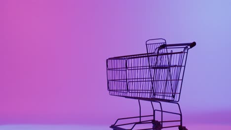 video of shopping trolley with copy space over neon purple background