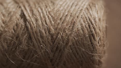 Micro-video-of-close-up-of-spool-with-brown-thread-with-copy-space