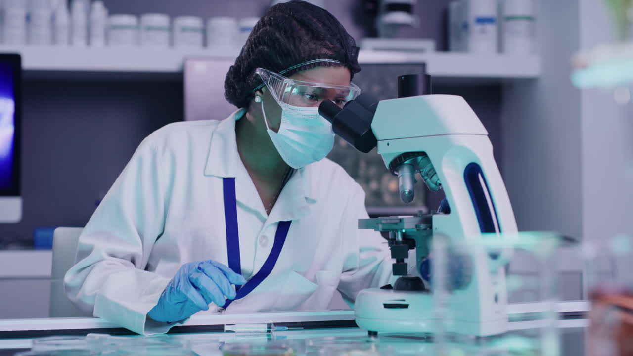 African american scientist use a microscope