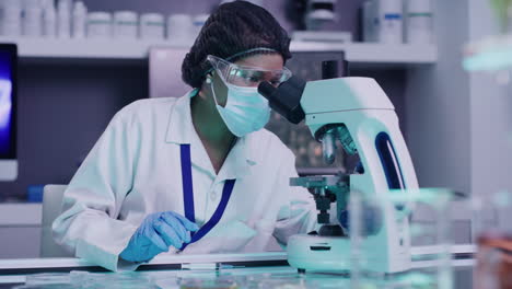científico afroamericano usa un microscopio
