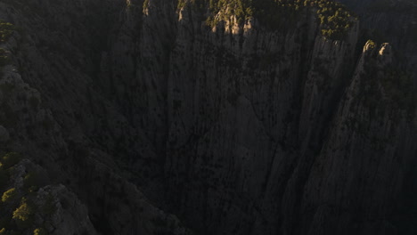 Imposing-cliff-peaks-on-rock-formation-and-sunlight-breaking-over-shadows