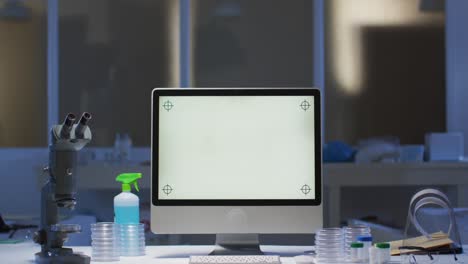 computadora de escritorio con pantalla iluminada en una estación de trabajo en un laboratorio vacío