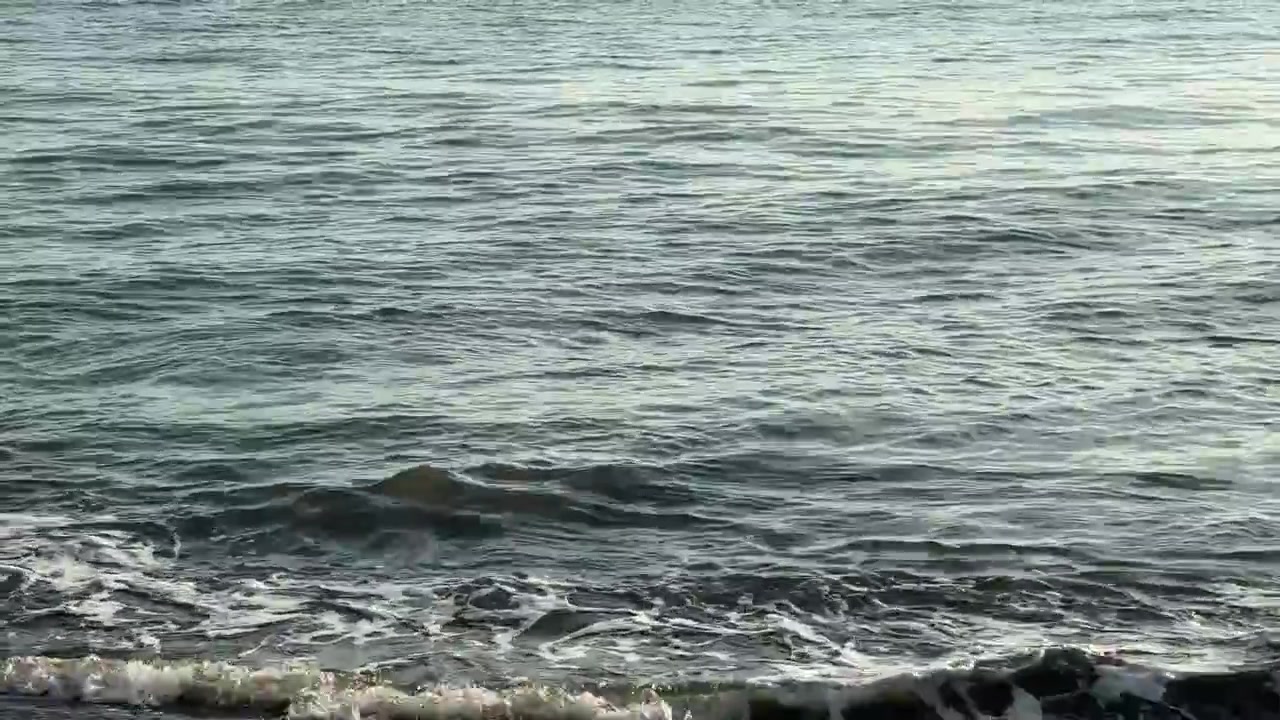 Onde oceaniche calme che si infrangono dolcemente sulla riva.