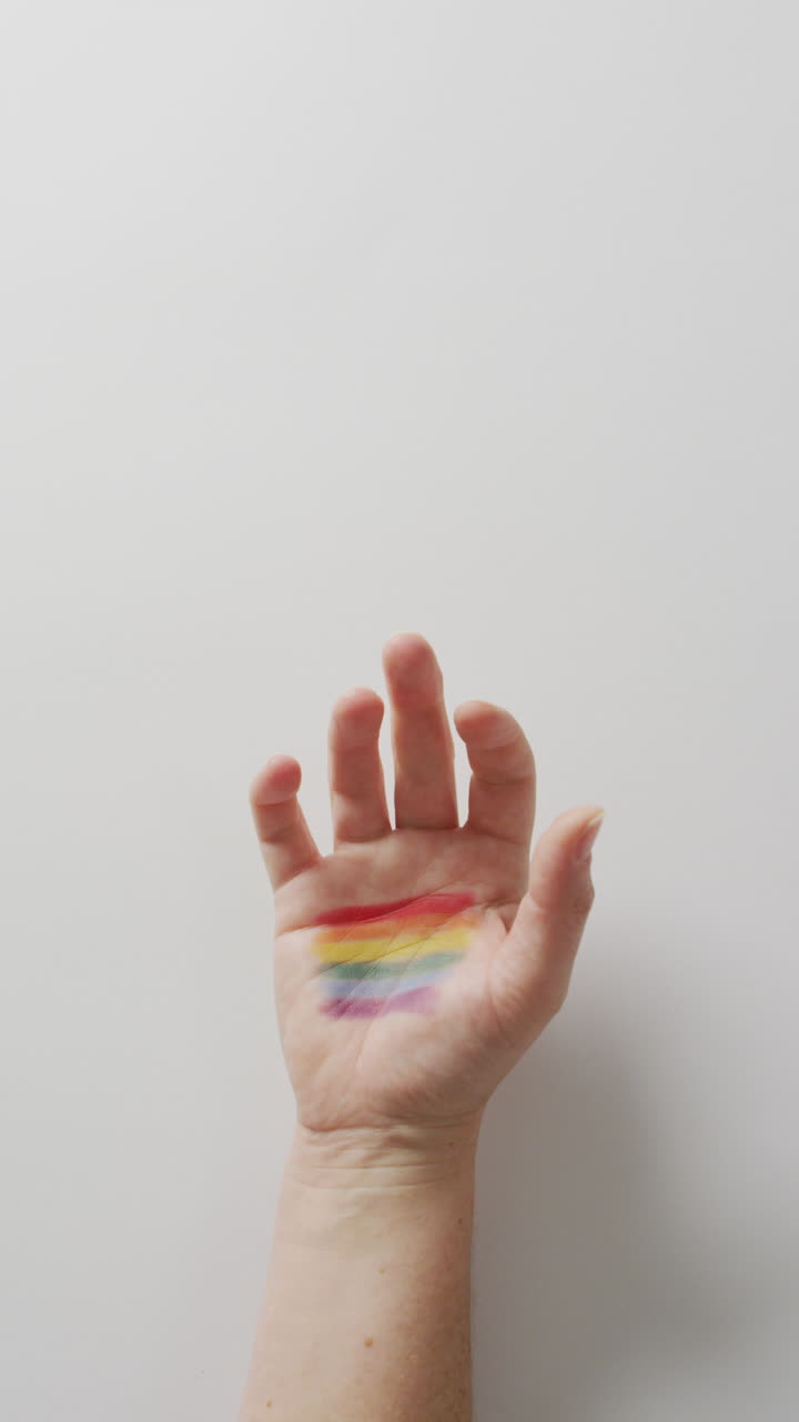 video vertical de primer plano de la mano con la bandera del orgullo