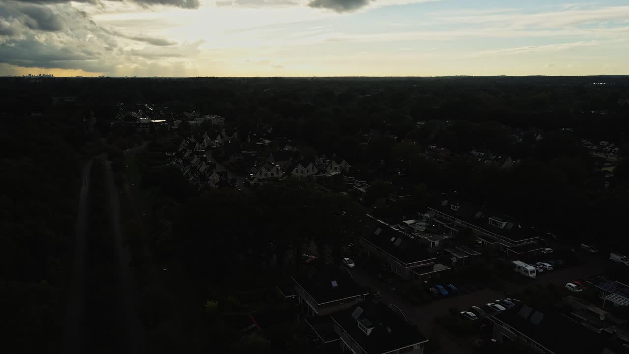 Beautiful aerial of a rural suburban neighborhood with a gorgeous sunset in the background