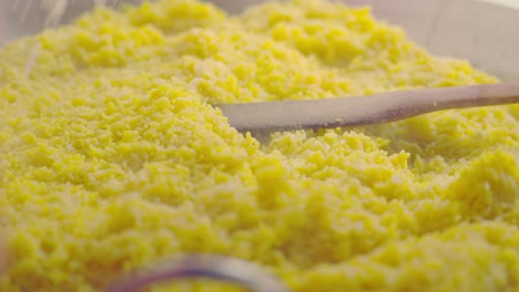 incorporando queso parmesano encima de arroz y pollo y mezclando