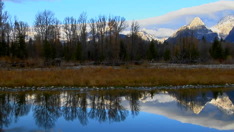 as montanhas grand teton são perfeitamente refletidas em um lago de montanha 1