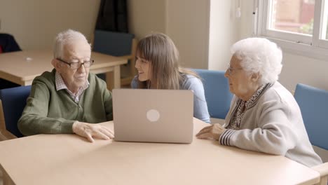 granddaughter helping to her grandparents to use the laptop