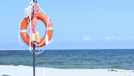 orange lifebuoy ring circle on beach blue sea, sky scenery background, sunny day