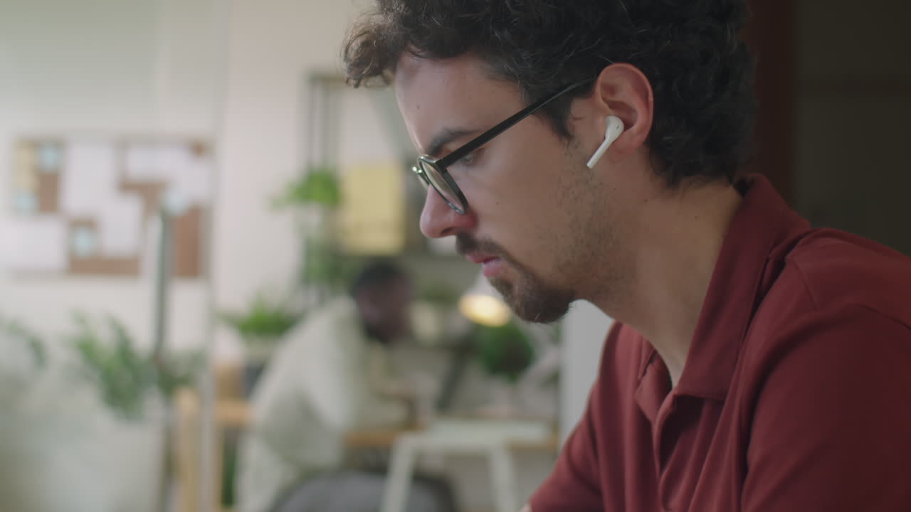 Hombre escribiendo en un portátil en el trabajo en la oficina