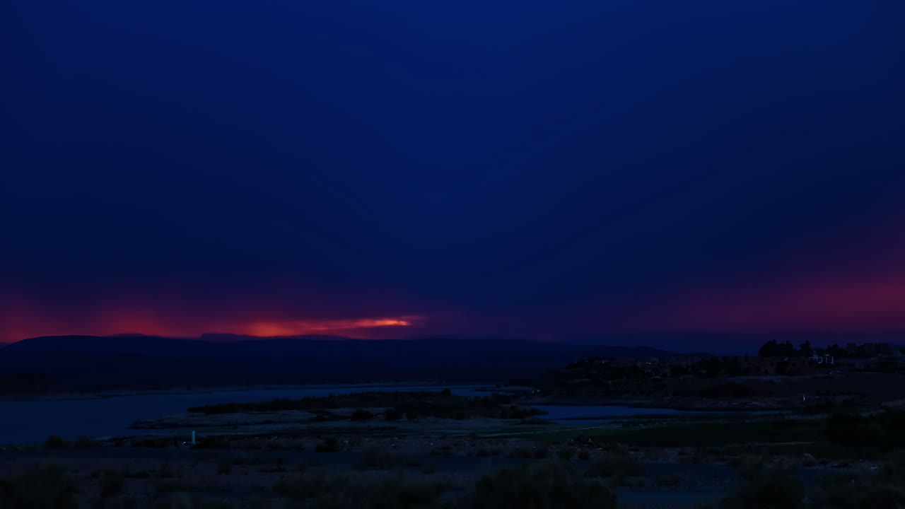 바다에서 일몰 시간 후 주황색 하늘을 덮는 어두운 구름의 저속 촬영