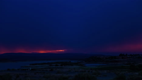 Time-lapse-shot-of-dark-clouds-covering-orange-sky-after-sunset-time-at-sea