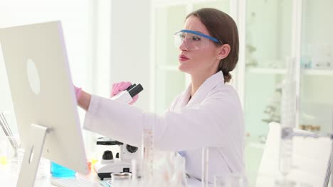 young female scientist conducting research with a microscope in a lab
