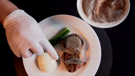 Eine-Hand-Des-Küchenchefs,-Die-Soße-In-Ein-Filet-Mignon-Gibt