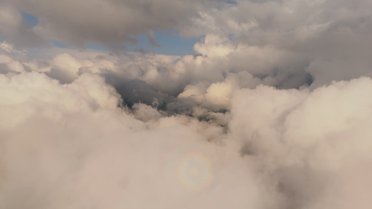 Fluffy clouds cluster together, forming dense layers under soft sunlight above