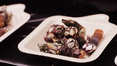 a close-up of assorted shellfish, highlighting their unique textures and colors in a market setting.