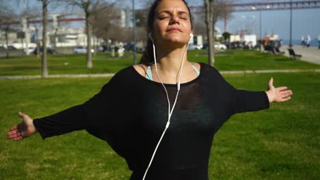 Brunette-girl-with-closed-eyes-exercising-in-park