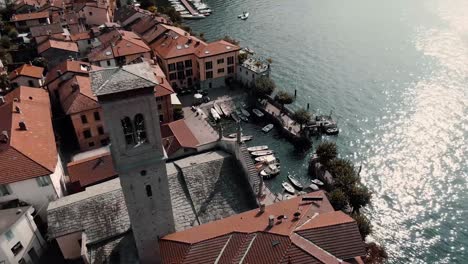 vista aérea de la parroquia de santa tecla a orillas del lago de como en torno, como, italia - disparo de drones en órbita