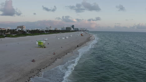South-Beach-Miami,-Ocean-Drive-Aerial-perspective-over-the-waves-crashing-on-the-coastline-during-sunrise