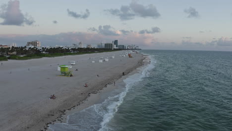 south beach miami, ocean drive aerial perspective over the waves crashing on the coastline during sunrise