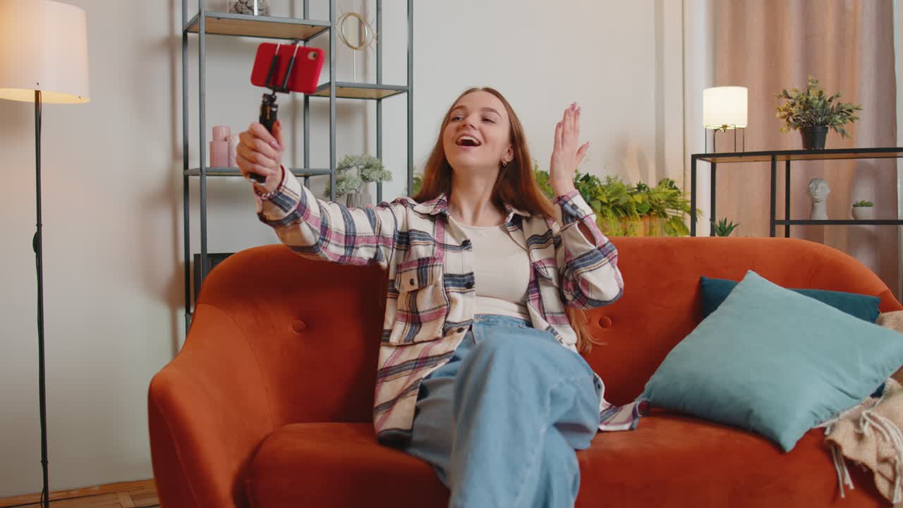 Una blogger influencer che si fa un selfie sullo smartphone fa un video virtuale sui social media online a casa