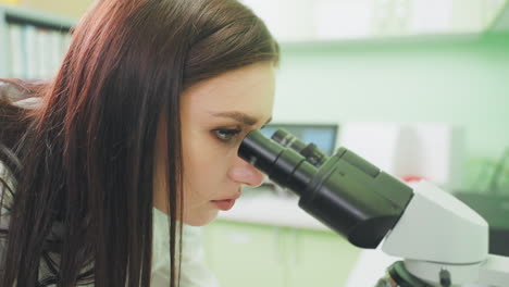 científico examinando la muestra bajo el microscopio