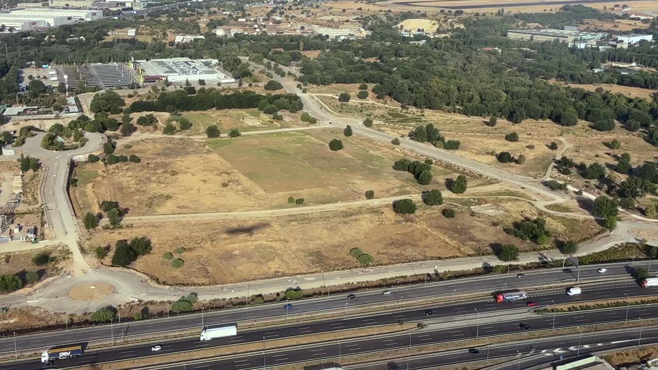 Aerial left side view taken from a jet cockpit of the shadow of the plane over the grounjd on final approach to Madrid airport, in a summer morning