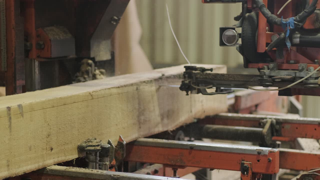 Nahaufnahme einer Sägemaschine, die einen großen Holzstamm zersägt