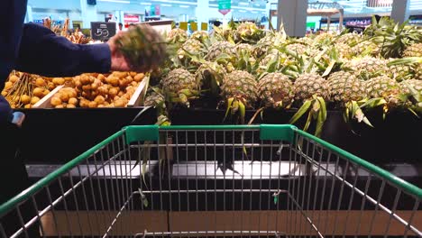 Junger-Mann-Mit-Einkaufswagen-Wählt-Obst-Und-Gemüse-In-Einem-Supermarkt