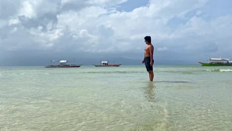 Joven-Turista-Admirando-La-Playa-Tropical-Llena-De-Botes-Bangka---Viajes-Y-Destinos-Filipinos