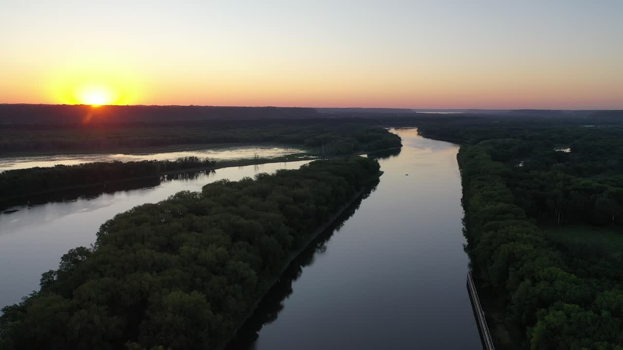 amanecer sobre un río con un bosque exuberante