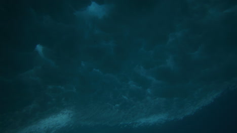 Underwater-angle-of-ocean-wave-crashing-and-spreading-textured-speckled-pattern-across-surface