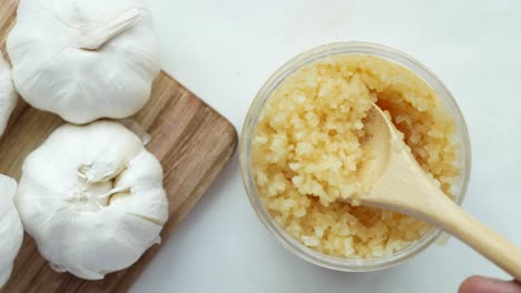 close up of minced garlic on a wooden spoon ,