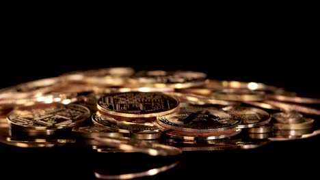 single golden coin spins and settles on pile of cryptocurrency tokens, dramatic studio lighting