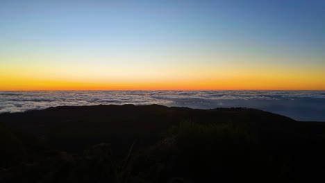 toma de lapso de tiempo de nubes en movimiento durante la puesta de sol dorada sobre la cima de la montaña