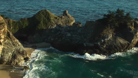 Panleft-Shot-Of-A-Rocky-California-Coast-And-A-Waterfall-Crashing-Down-Into-A-Secluded-Pool-At-Julia-Pfeiffer-Burns-State-Park