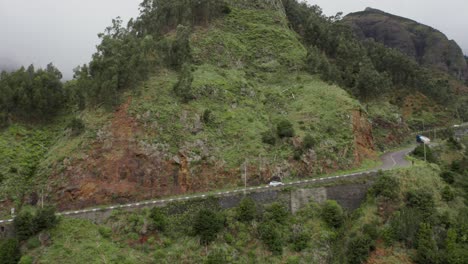 automobile driving up steep mountain road on volcanic island, aerial