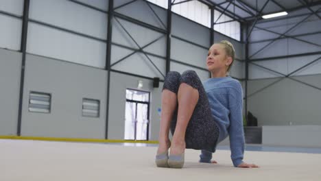 teenage female gymnast performing at sports hall