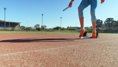 caucasian female athlete taking starting position on a running track at sports venue 4k